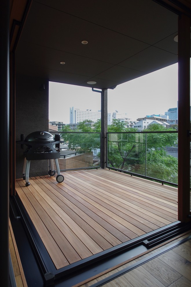 Inspiration for a mid-sized courtyard patio in Tokyo with an outdoor kitchen, decking and a roof extension.