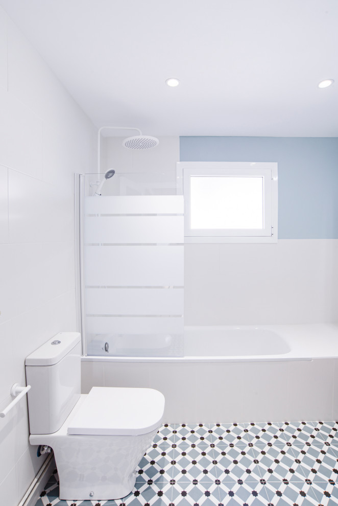 Idées déco pour une grande salle de bain principale et grise et blanche moderne avec un placard à porte plane, des portes de placard blanches, une baignoire posée, un combiné douche/baignoire, WC à poser, un carrelage blanc, des carreaux de céramique, un mur bleu, un sol en carrelage de céramique, un lavabo posé, un plan de toilette en surface solide, un sol multicolore, une cabine de douche à porte battante, un plan de toilette blanc, une fenêtre, meuble simple vasque et meuble-lavabo sur pied.
