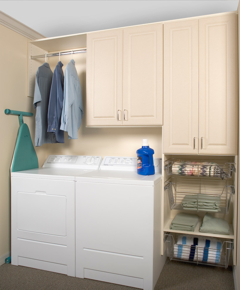 This is an example of a mid-sized traditional single-wall dedicated laundry room in Charleston with raised-panel cabinets, beige cabinets, beige walls, carpet, a side-by-side washer and dryer and brown floor.