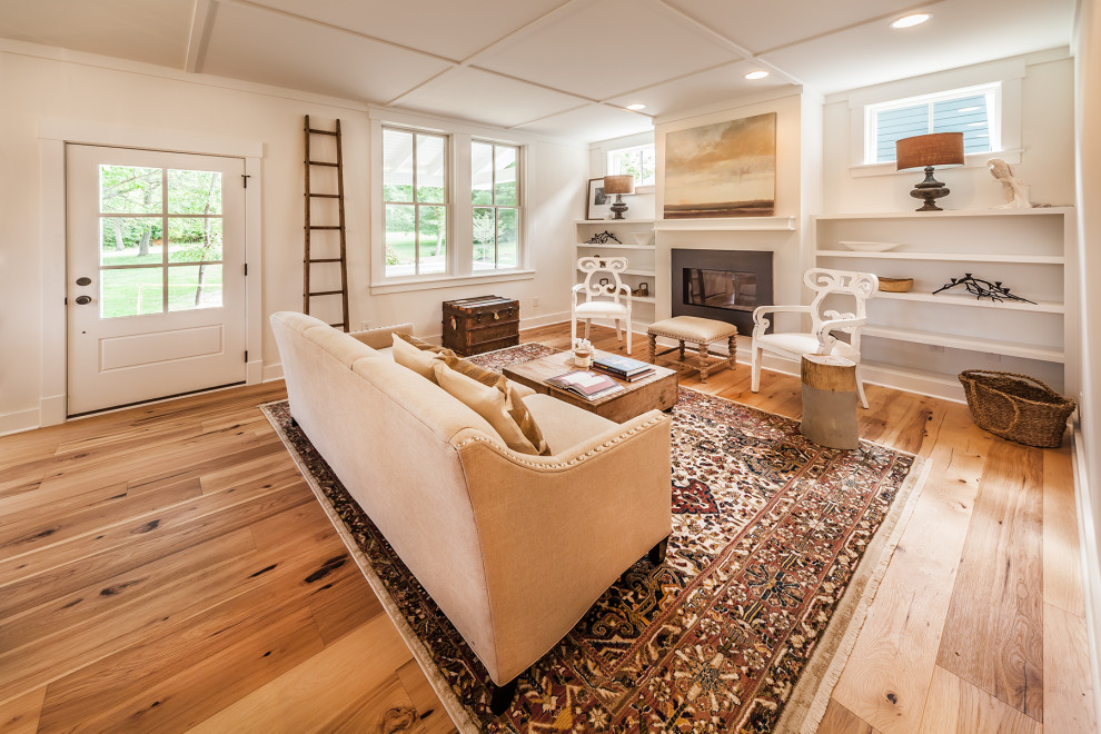 Photo of a mid-sized arts and crafts open concept living room in Indianapolis with white walls, medium hardwood floors and a standard fireplace.
