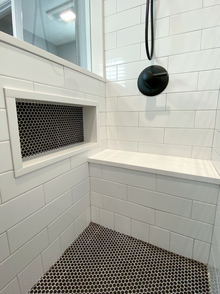 На фото: ванная комната в стиле неоклассика (современная классика) с фасадами в стиле шейкер, черными фасадами, душем в нише, унитазом-моноблоком, белой плиткой, плиткой кабанчик, серыми стенами, полом из керамогранита, душевой кабиной, врезной раковиной, столешницей из искусственного кварца, черным полом, душем с распашными дверями, белой столешницей, нишей, тумбой под одну раковину и встроенной тумбой с