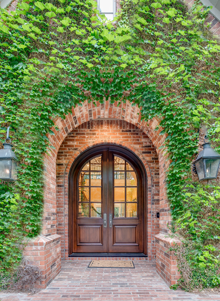 This is an example of a traditional entryway in Dallas with a double front door and a dark wood front door.