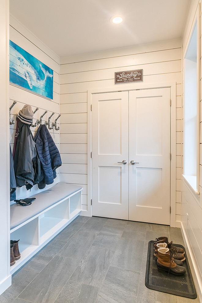 Photo of a mid-sized beach style mudroom in Seattle with white walls, porcelain floors, a single front door, a white front door and grey floor.