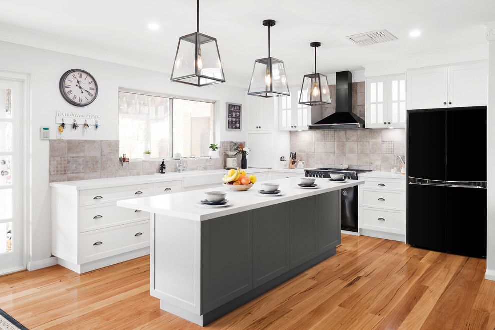 Inspiration for a large traditional l-shaped eat-in kitchen in Perth with shaker cabinets, white cabinets, black appliances, medium hardwood floors, brown floor, white benchtop, a farmhouse sink, beige splashback, with island, quartz benchtops and ceramic splashback.