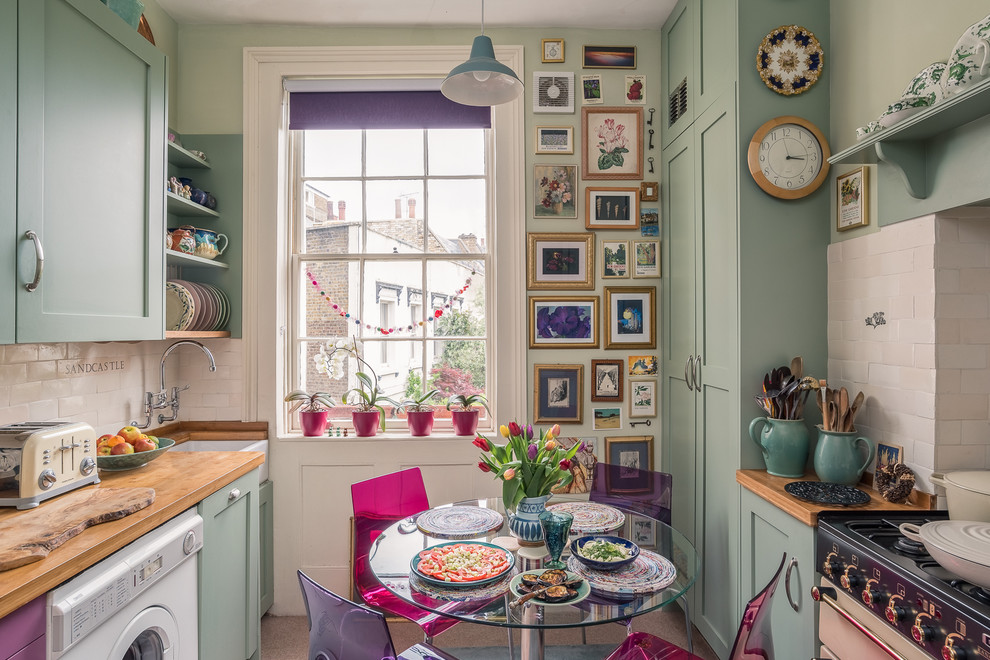 Inspiration for an eclectic galley eat-in kitchen in Surrey with a farmhouse sink, shaker cabinets, green cabinets, wood benchtops and white splashback.