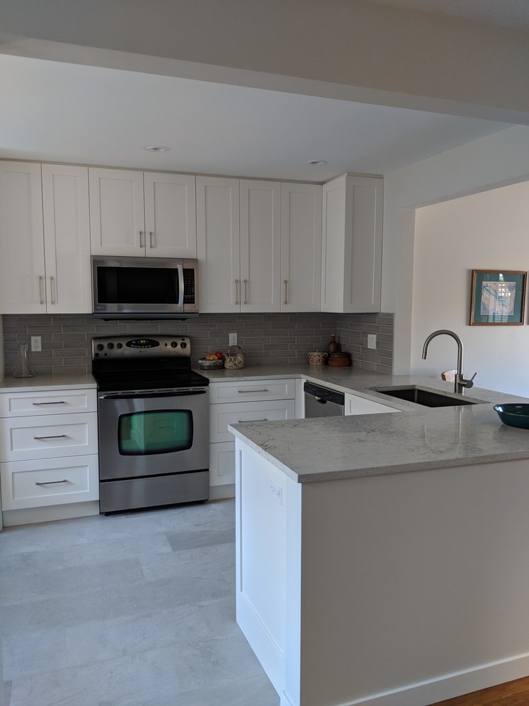 Example of a small transitional u-shaped vinyl floor and beige floor eat-in kitchen design in Vancouver with a single-bowl sink, shaker cabinets, white cabinets, quartz countertops, gray backsplash, ceramic backsplash, stainless steel appliances, no island and gray countertops