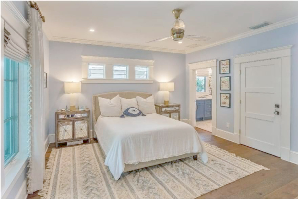 Ejemplo de dormitorio principal, blanco y blanco y madera marinero grande con paredes azules, suelo de madera clara y suelo marrón