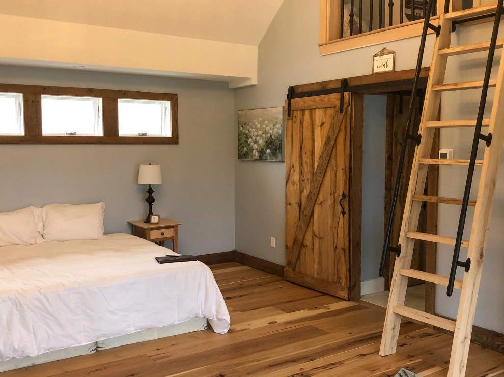 Imagen de dormitorio rural con suelo de madera en tonos medios y suelo marrón