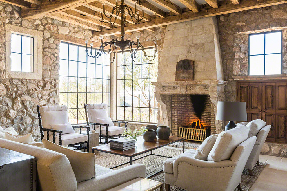 This is an example of a mediterranean formal living room in Phoenix with multi-coloured walls, limestone floors, a standard fireplace, a stone fireplace surround and beige floor.