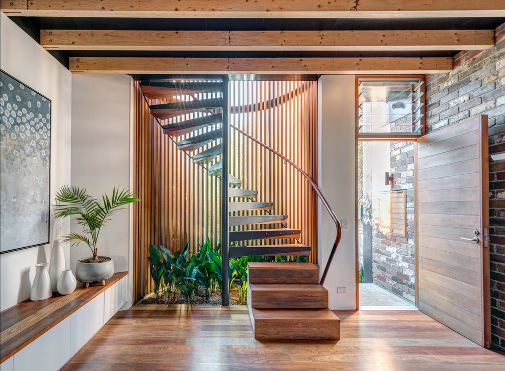 Photo of a mid-sized industrial wood spiral staircase in Sydney with wood railing and open risers.