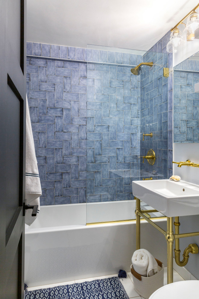 Пример оригинального дизайна: маленькая детская ванная комната в стиле неоклассика (современная классика) с белыми фасадами, ванной в нише, душем над ванной, раздельным унитазом, синей плиткой, керамической плиткой, белыми стенами, полом из керамической плитки, раковиной с пьедесталом, столешницей из искусственного камня, белым полом, открытым душем, белой столешницей, тумбой под одну раковину и встроенной тумбой для на участке и в саду