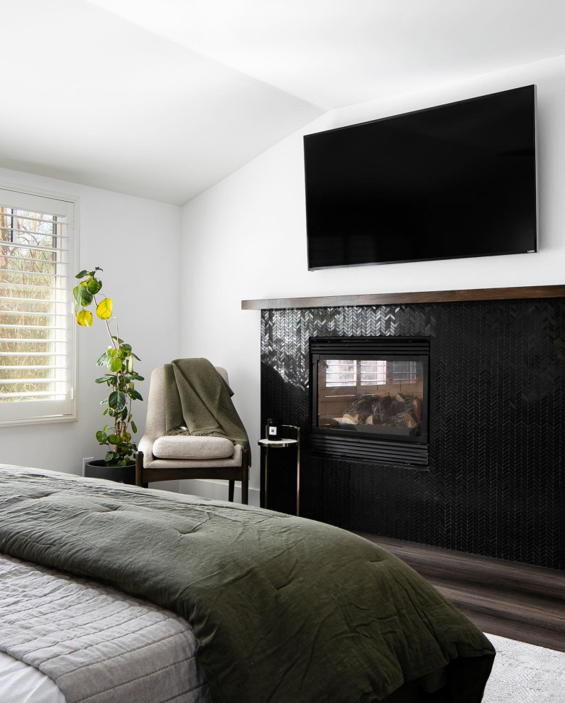 Photo of a mid-sized asian master bedroom in Los Angeles with green walls, dark hardwood floors, a corner fireplace and brown floor.