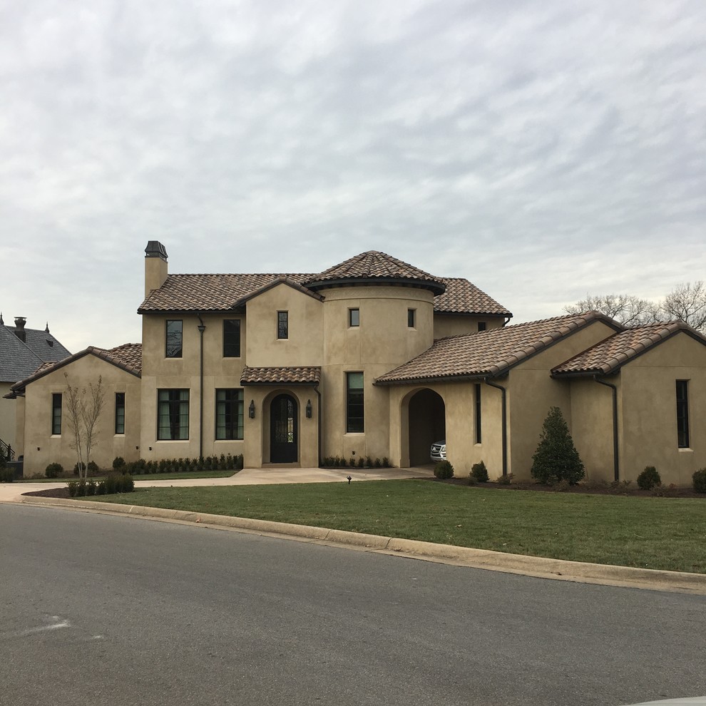 This is an example of a mid-sized mediterranean two-storey stucco beige exterior in Little Rock with a gable roof.