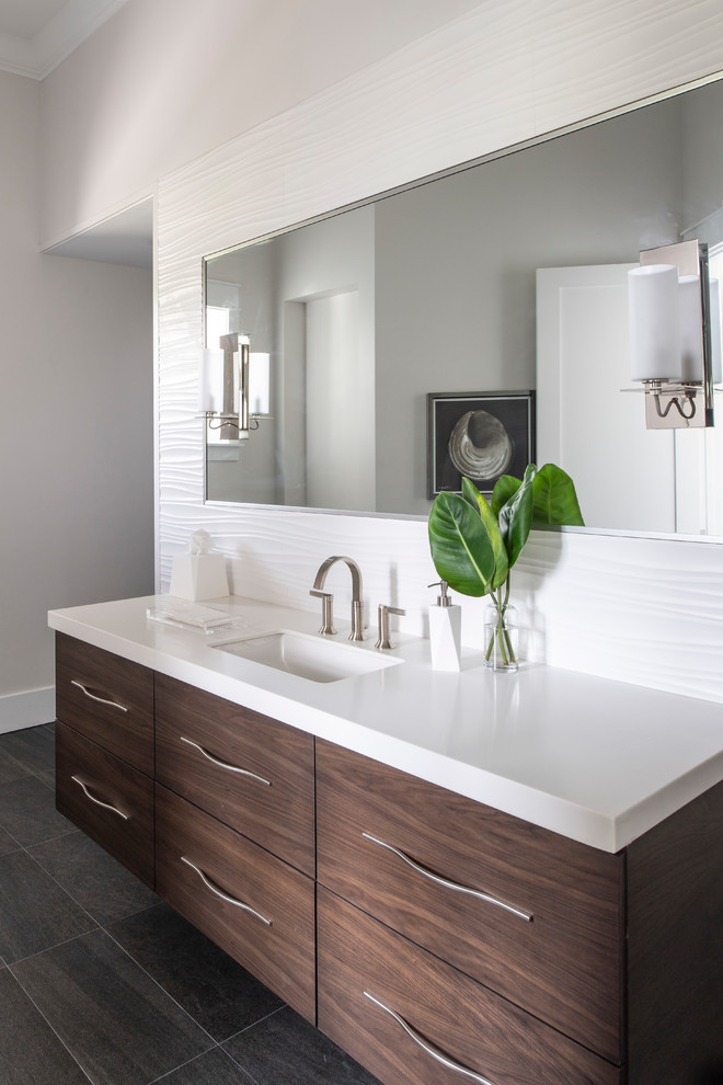 Small contemporary master bathroom in Los Angeles with shaker cabinets, medium wood cabinets, a curbless shower, a one-piece toilet, gray tile, porcelain tile, beige walls, porcelain floors, an undermount sink, engineered quartz benchtops, grey floor, a hinged shower door and white benchtops.