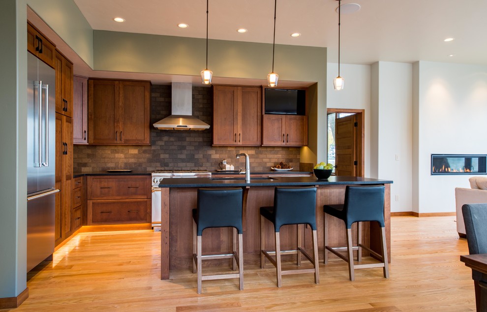 Inspiration for a large rustic l-shaped light wood floor and brown floor open concept kitchen remodel with an undermount sink, quartzite countertops, stainless steel appliances, an island, shaker cabinets, dark wood cabinets, brown backsplash and ceramic backsplash