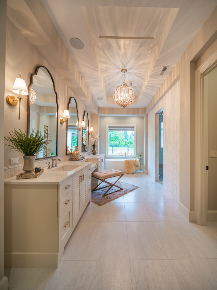 Photo of a mid-sized transitional master bathroom in Portland with louvered cabinets, white cabinets, a freestanding tub, an open shower, white tile, porcelain tile, beige walls, porcelain floors, an undermount sink, engineered quartz benchtops, white floor, an open shower, white benchtops and a double vanity.