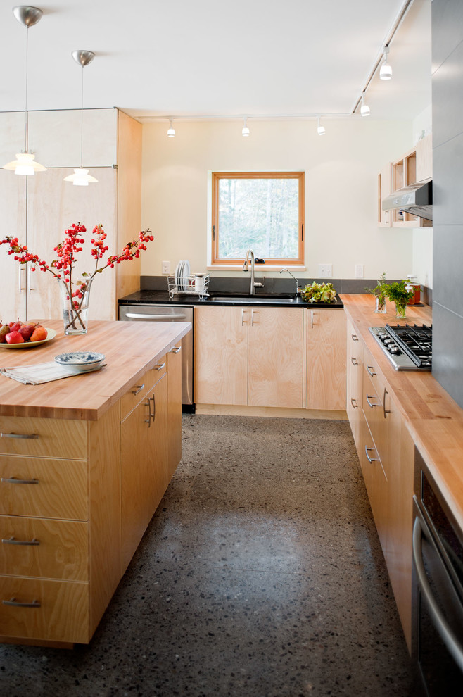 Inspiration for a contemporary l-shaped kitchen in Burlington with an undermount sink, flat-panel cabinets, light wood cabinets, wood benchtops, stainless steel appliances, with island and concrete floors.