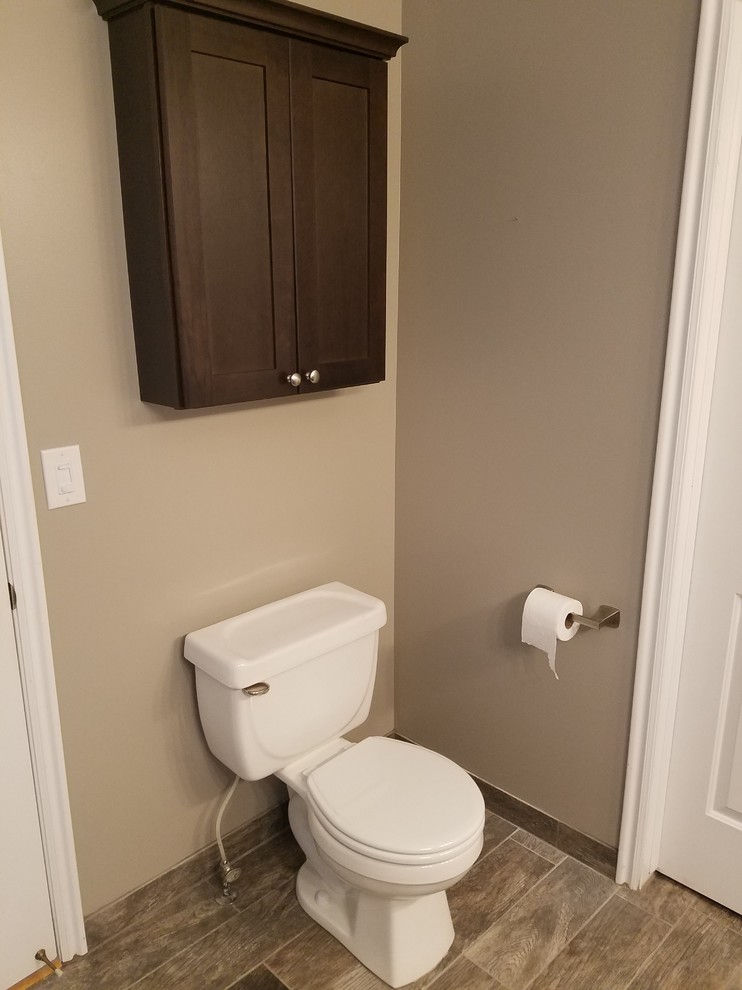 Mid-sized transitional powder room in Salt Lake City with shaker cabinets, dark wood cabinets, a two-piece toilet, brown tile, ceramic tile, beige walls, porcelain floors, an undermount sink and quartzite benchtops.