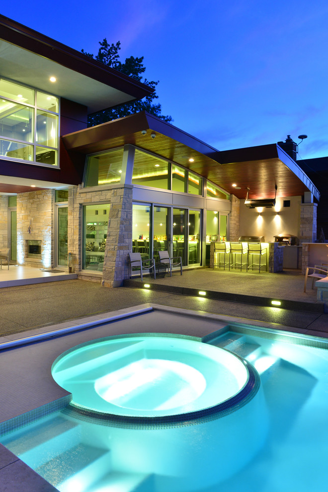 This is an example of a contemporary pool in Detroit with a hot tub.