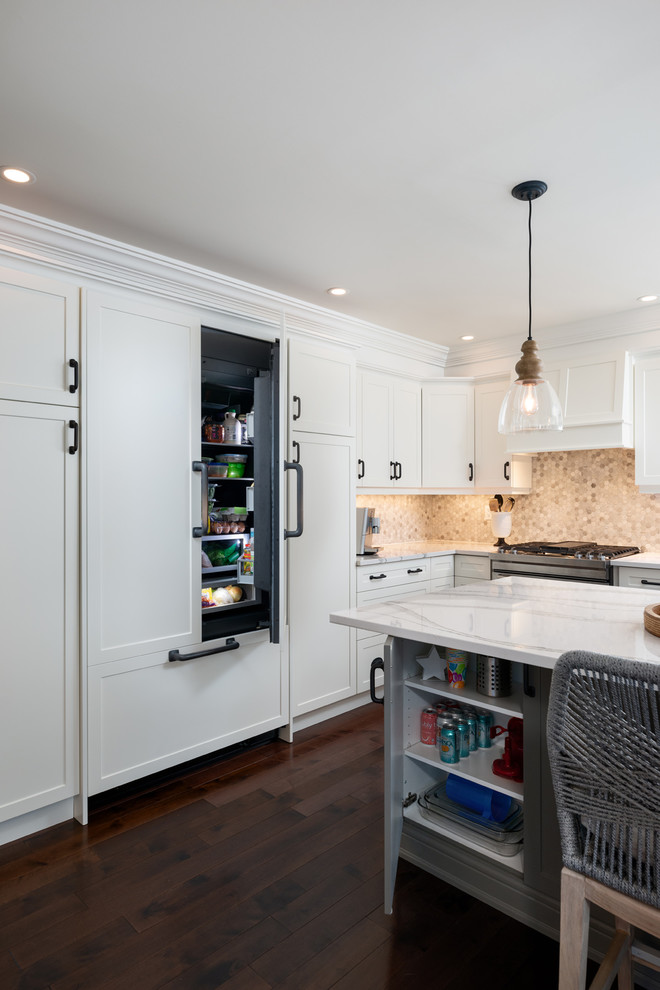 Inspiration for a transitional dark wood floor and brown floor kitchen remodel with white cabinets, quartz countertops, paneled appliances, an island and white countertops