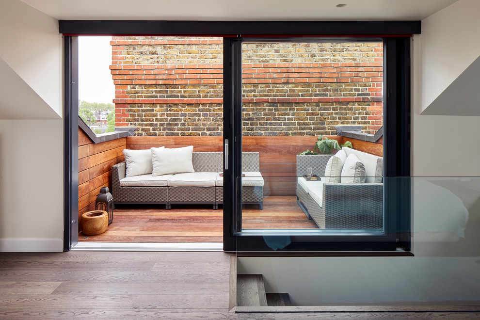 This is an example of a small contemporary rooftop deck in London with with dock and a roof extension.