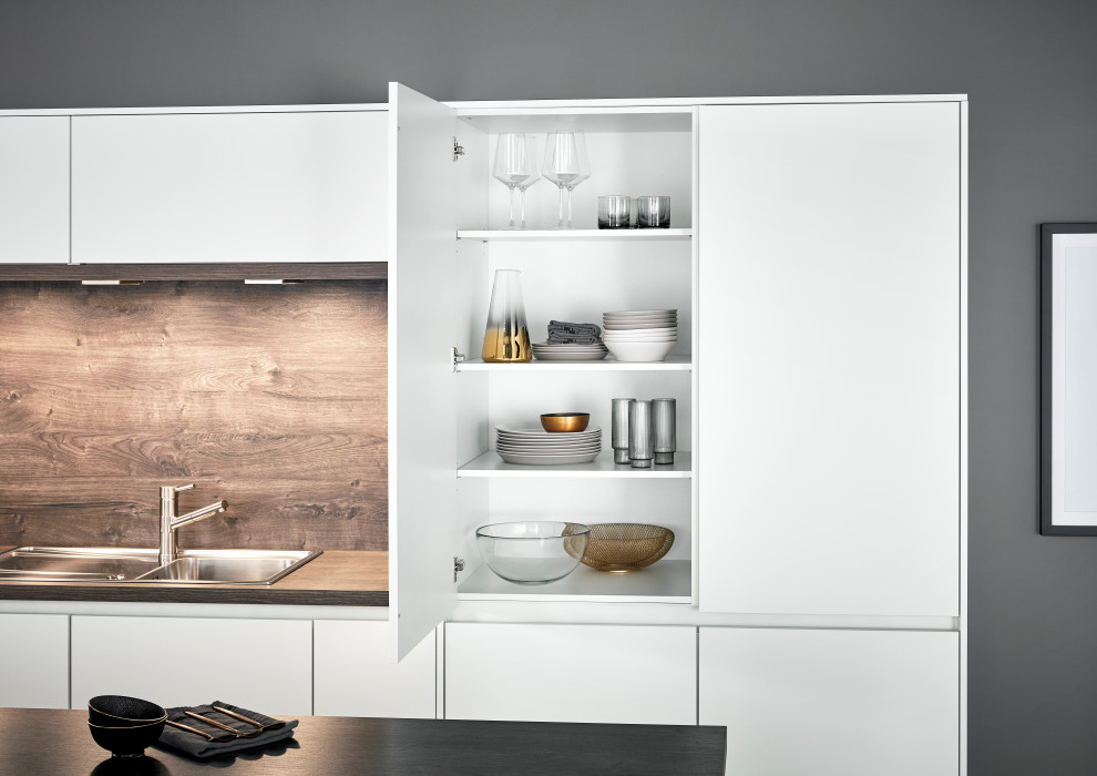 Aménagement d'une cuisine contemporaine avec des portes de placard blanches et un plan de travail en bois.
