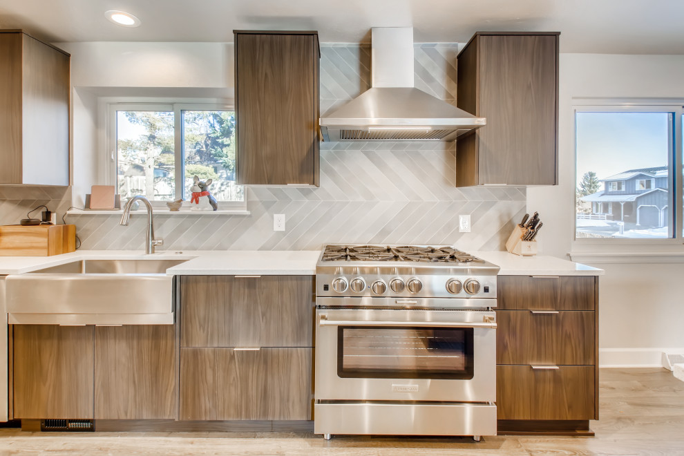 Inspiration for a large l-shaped eat-in kitchen in Denver with a drop-in sink, flat-panel cabinets, brown cabinets, quartzite benchtops, grey splashback, ceramic splashback, stainless steel appliances, vinyl floors, with island, brown floor, white benchtop and wallpaper.