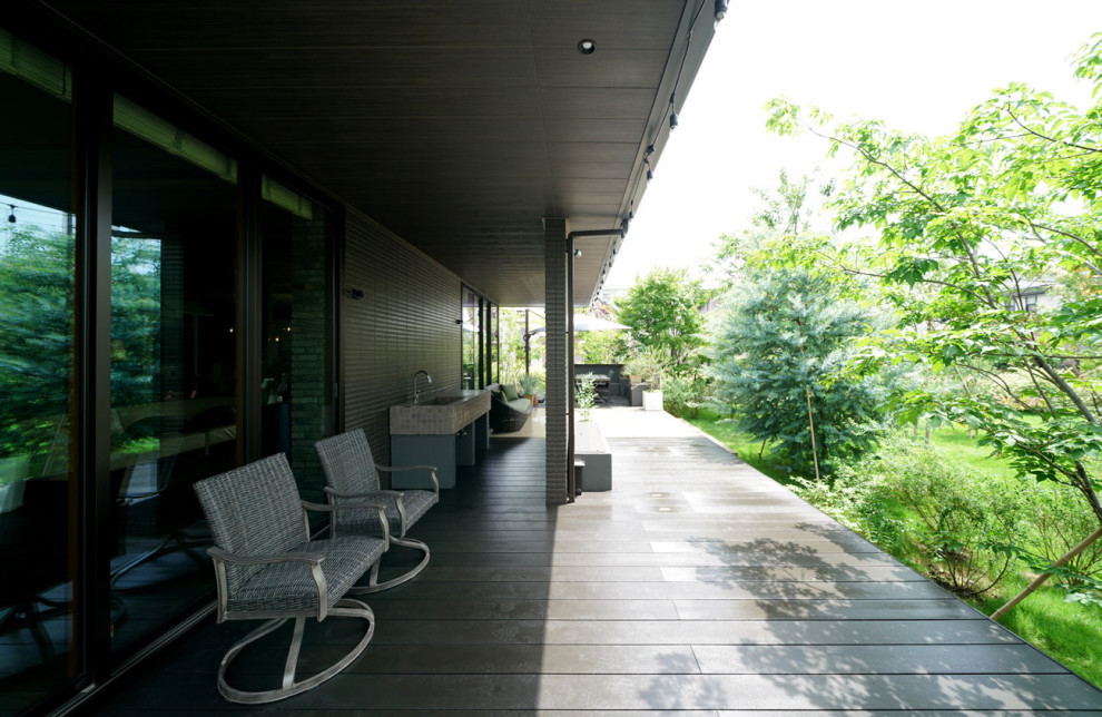 Aménagement d'une très grande terrasse arrière et au rez-de-chaussée avec une cuisine d'été et une extension de toiture.