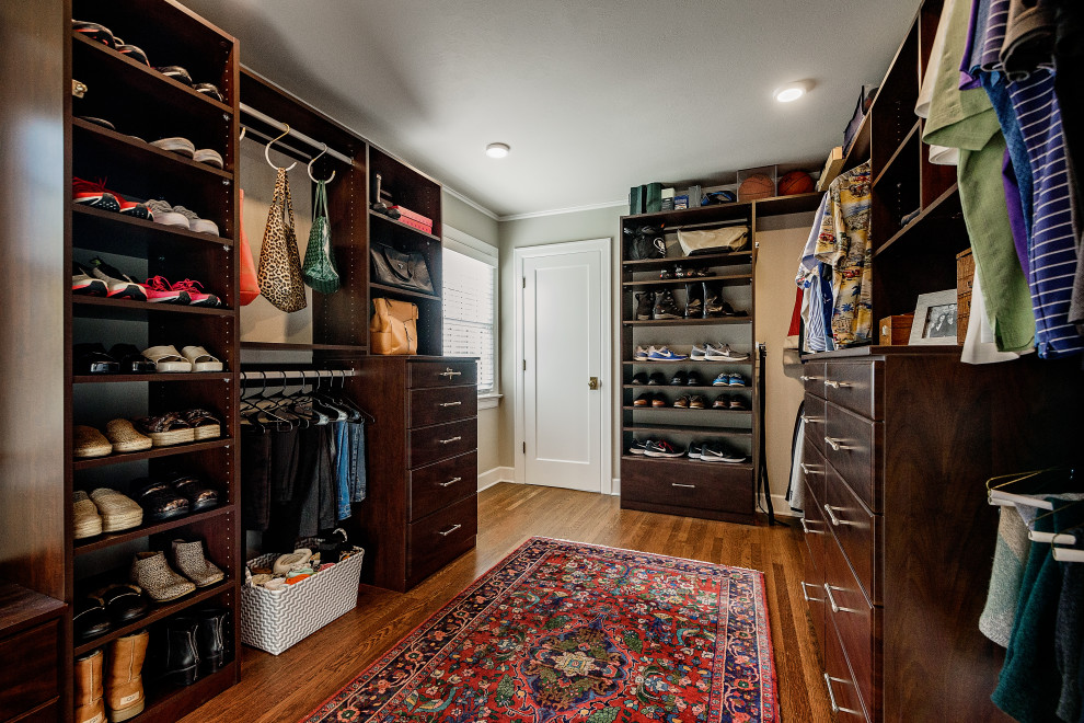 Photo of a traditional gender-neutral storage and wardrobe in Portland with dark wood cabinets and medium hardwood floors.