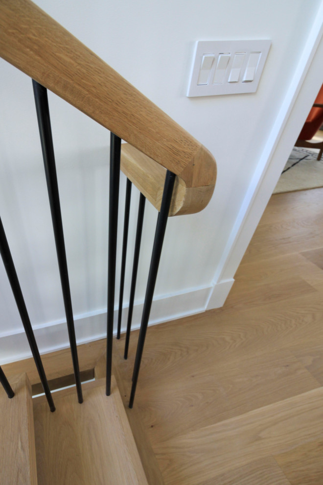 This is an example of an expansive modern wood floating mixed railing staircase in DC Metro with tongue and groove walls.