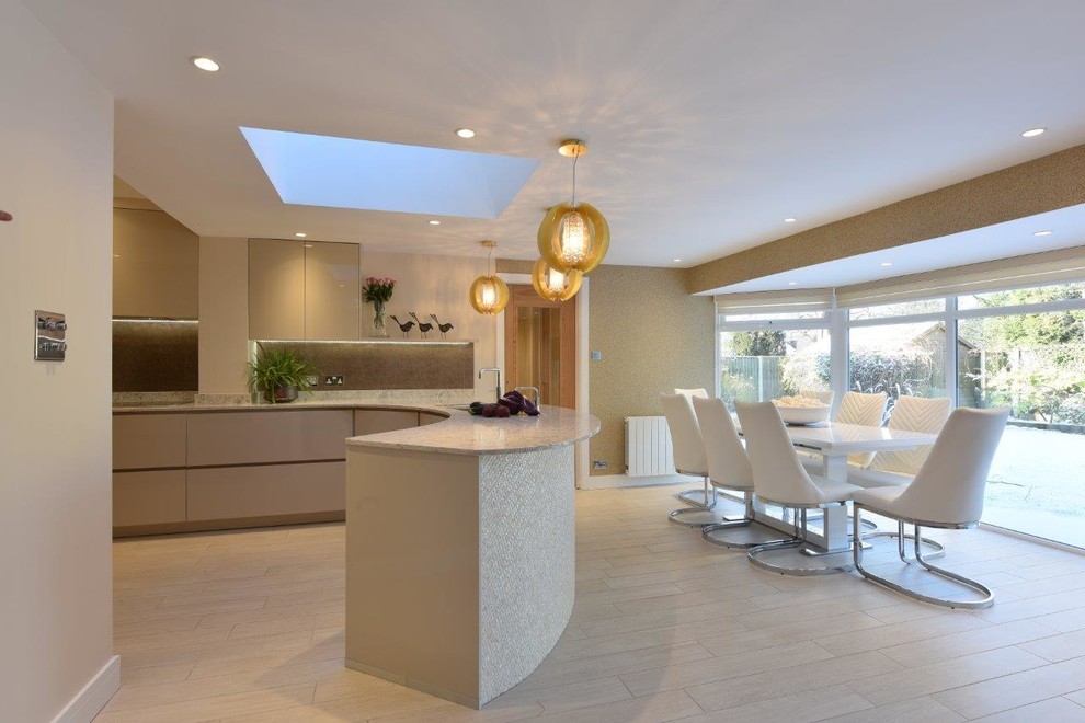 Inspiration for a mid-sized contemporary u-shaped open plan kitchen in Manchester with an undermount sink, flat-panel cabinets, grey cabinets, quartzite benchtops, metallic splashback, glass sheet splashback, black appliances, porcelain floors, no island, beige floor and beige benchtop.