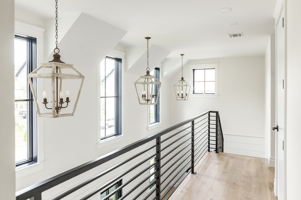 Mid-sized farmhouse light wood floor, beige floor and shiplap wall hallway photo in New York with white walls
