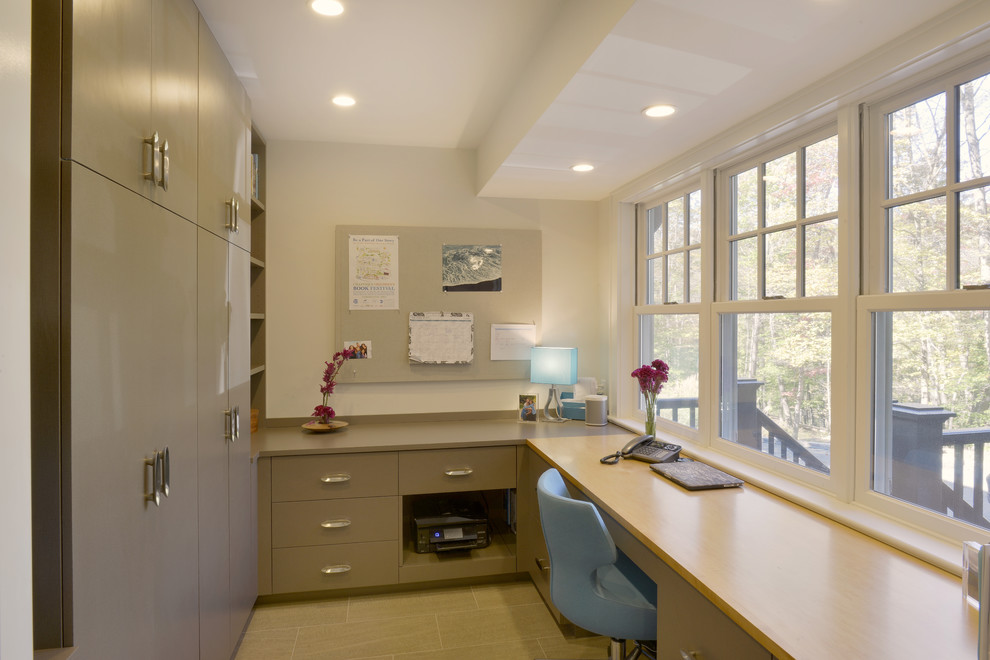 Mid-sized transitional home office in New York with beige walls, porcelain floors, a built-in desk and beige floor.