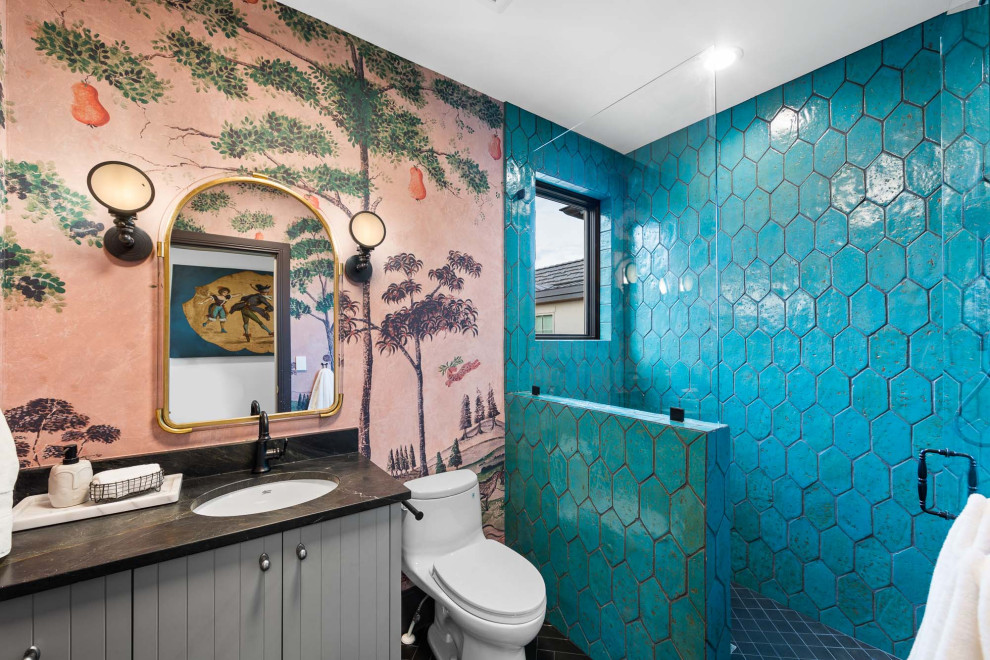 Exemple d'une salle de bain chic pour enfant avec un carrelage bleu, un plan de toilette noir, meuble simple vasque et du papier peint.