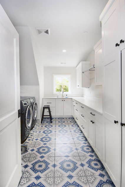 This is an example of a large transitional galley dedicated laundry room in Denver with a drop-in sink, shaker cabinets, white cabinets, quartz benchtops, grey walls, ceramic floors, a side-by-side washer and dryer and blue floor.