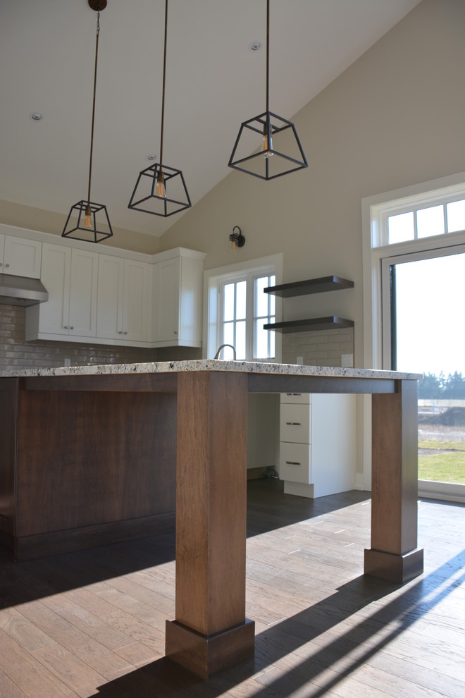 Example of a mid-sized transitional u-shaped light wood floor eat-in kitchen design in Toronto with a double-bowl sink, shaker cabinets, white cabinets, granite countertops, gray backsplash, subway tile backsplash, stainless steel appliances and an island
