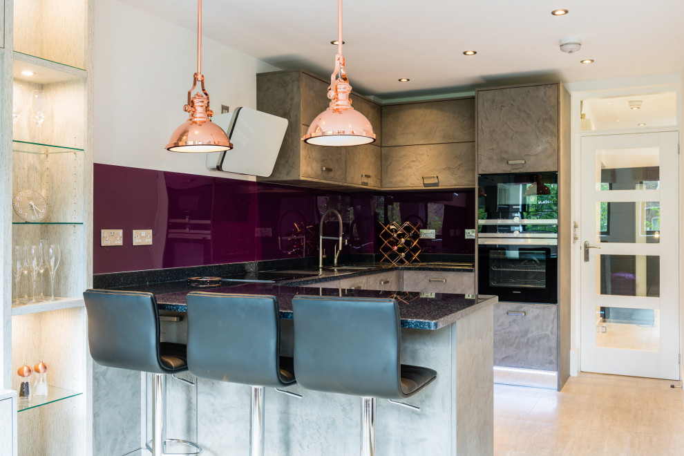 Inspiration for a contemporary u-shaped open plan kitchen in London with a drop-in sink, flat-panel cabinets, grey cabinets, solid surface benchtops, stainless steel appliances, ceramic floors, a peninsula, white floor and black benchtop.