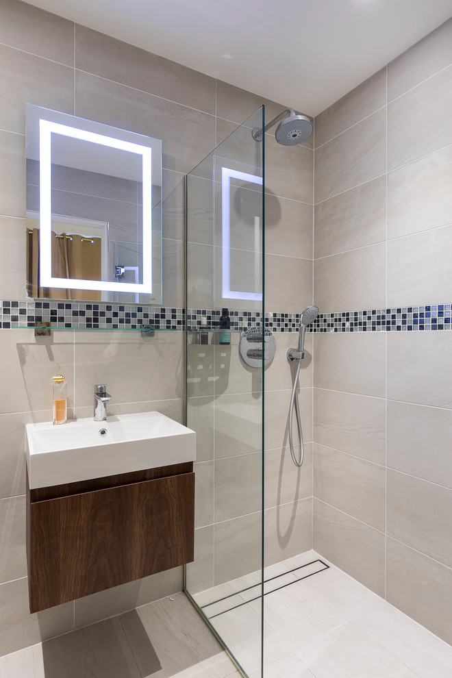 Small contemporary master bathroom in London with flat-panel cabinets, dark wood cabinets, an open shower, a two-piece toilet, beige tile, blue tile, multi-coloured tile, porcelain tile, beige walls, porcelain floors, an integrated sink, beige floor and a hinged shower door.