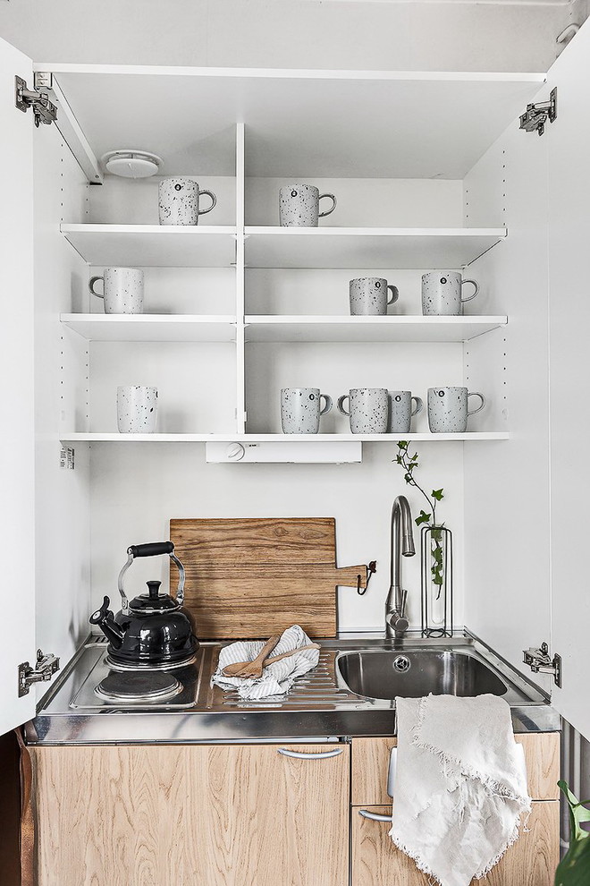 Inspiration for a small scandinavian kitchen in Stockholm with open cabinets, stainless steel cabinets, stainless steel benchtops and no island.