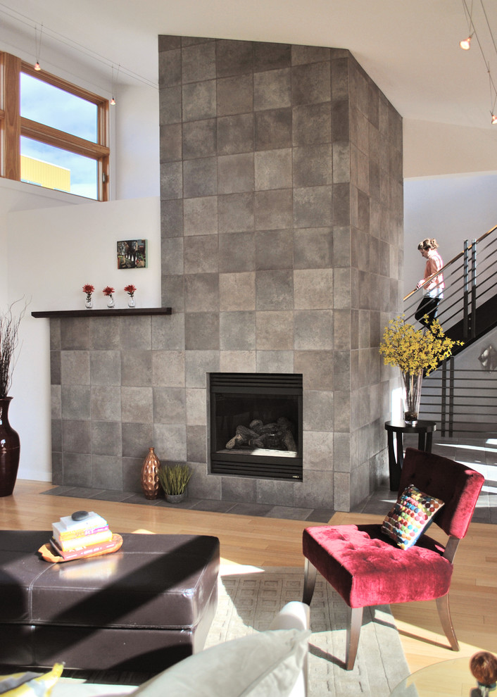 Photo of a modern living room in Denver with bamboo floors and a tile fireplace surround.