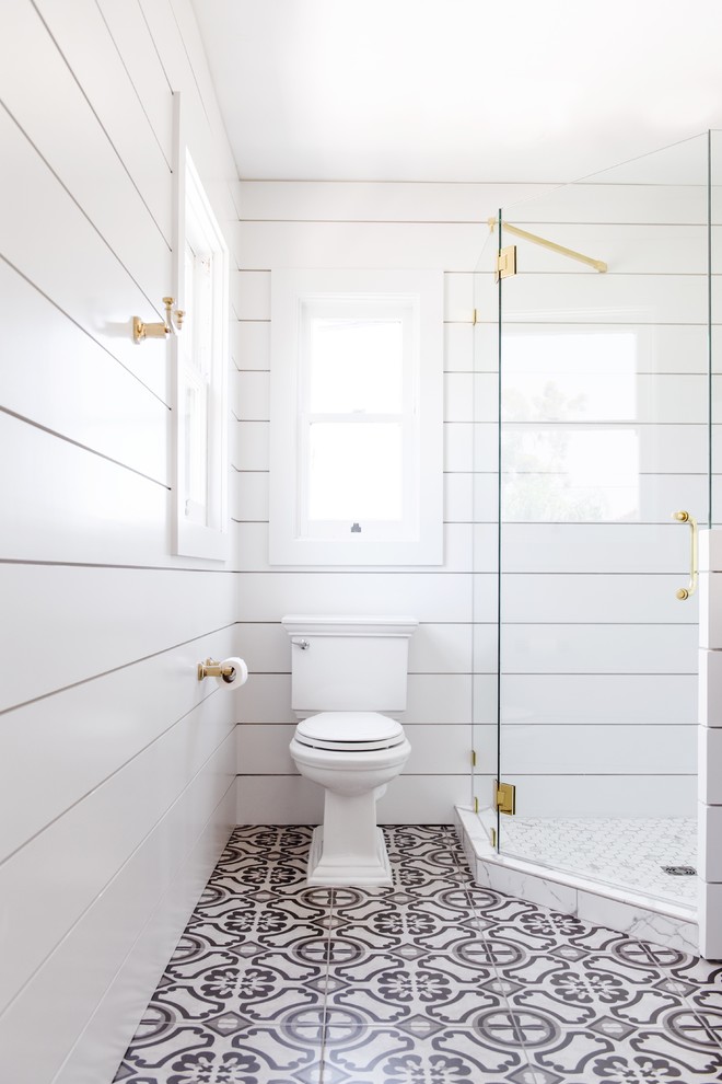 Inspiration for a mid-sized country 3/4 bathroom in San Diego with a corner shower, a two-piece toilet, white walls, cement tiles, white floor and a hinged shower door.