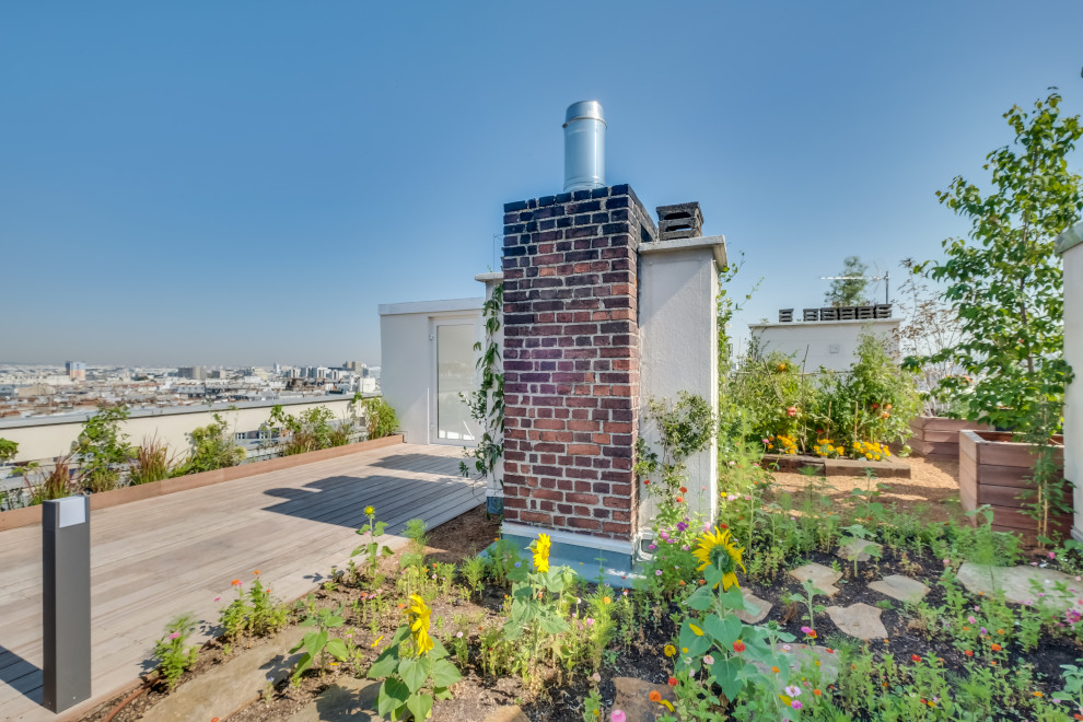 Exemple d'un toit terrasse sur le toit nature de taille moyenne avec une cheminée et un garde-corps en bois.