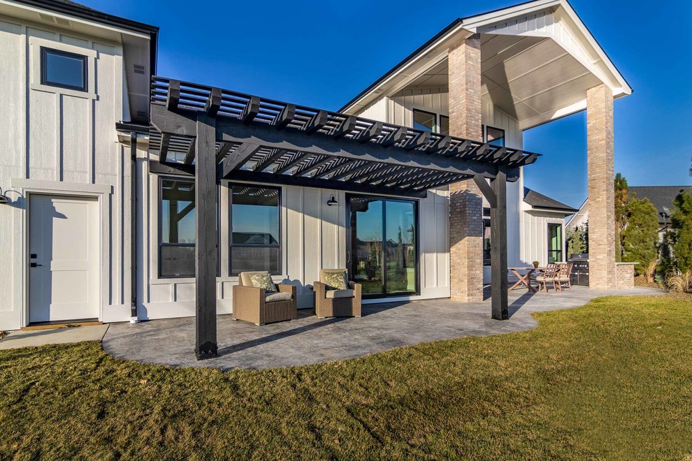 Inspiration for a country backyard patio in Boise with an outdoor kitchen, stamped concrete and a pergola.