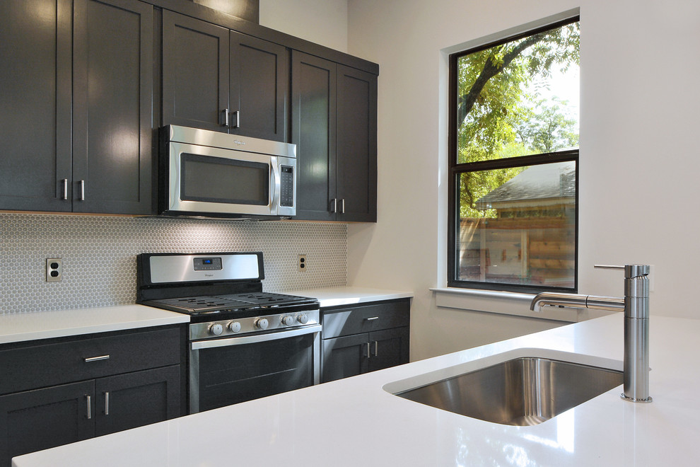 Inspiration for a modern galley concrete floor kitchen remodel in Austin with quartz countertops, gray backsplash and an island
