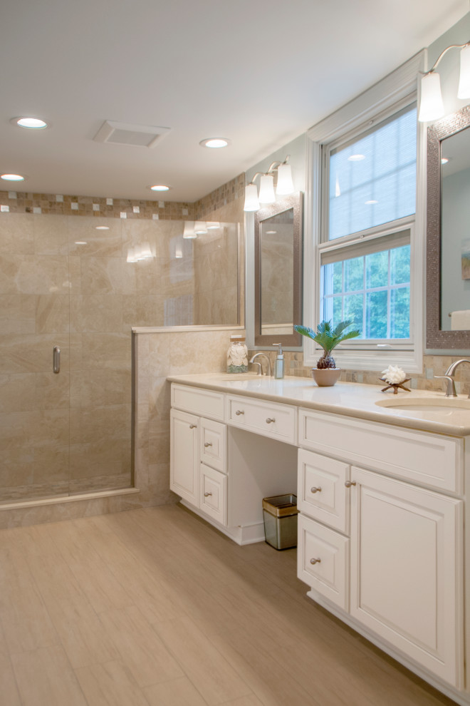 Design ideas for a large beach style master bathroom in Other with raised-panel cabinets, white cabinets, an open shower, a two-piece toilet, beige tile, porcelain tile, blue walls, porcelain floors, an undermount sink, engineered quartz benchtops, beige floor, a hinged shower door, beige benchtops, a shower seat, a double vanity and a freestanding vanity.