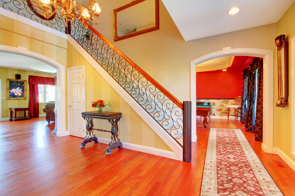 Photo of a traditional hallway in Baltimore with yellow walls and medium hardwood floors.