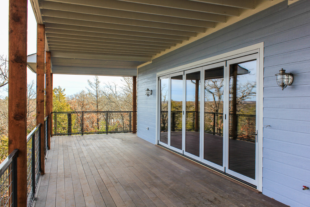 Photo of a large beach style backyard patio in Austin with decking and a roof extension.