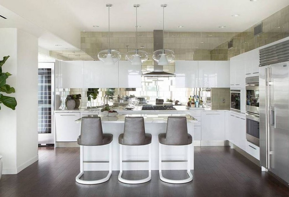 Photo of a mid-sized contemporary l-shaped eat-in kitchen in Los Angeles with flat-panel cabinets, white cabinets, solid surface benchtops, metallic splashback, mirror splashback, stainless steel appliances, dark hardwood floors, with island and brown floor.