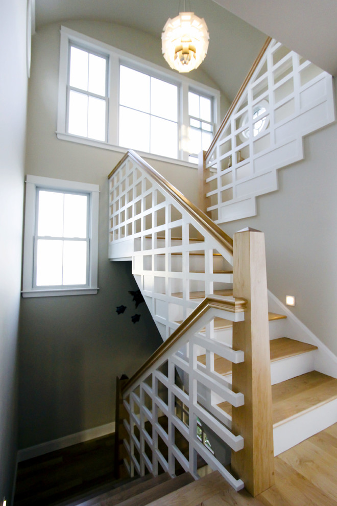 This is an example of a large eclectic wood u-shaped staircase in Boston with painted wood risers.