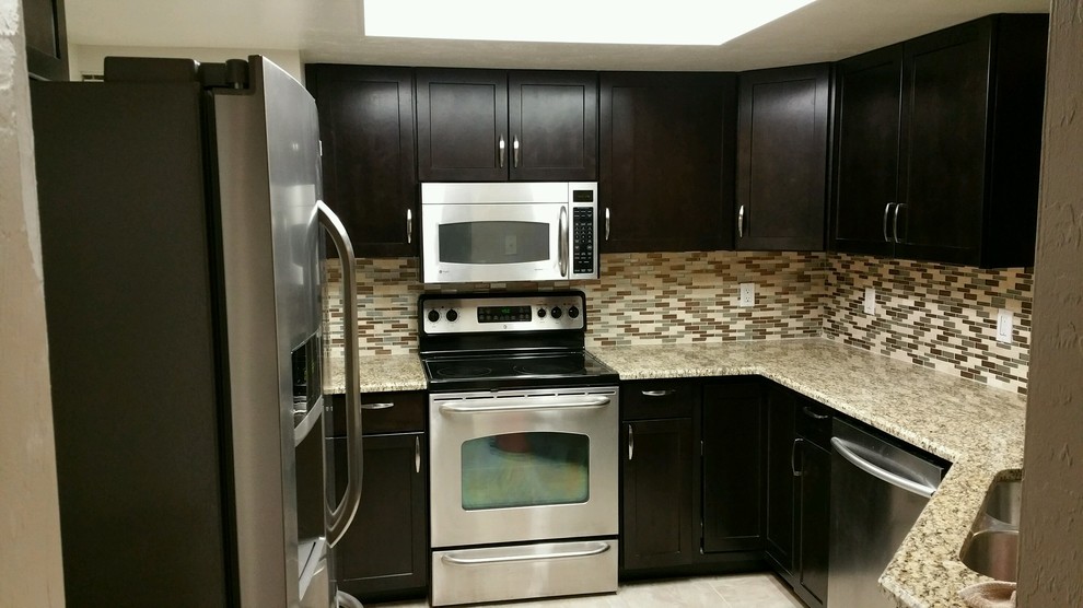 Enclosed kitchen - small transitional u-shaped ceramic tile enclosed kitchen idea in Miami with a double-bowl sink, shaker cabinets, dark wood cabinets, granite countertops, multicolored backsplash, glass tile backsplash, stainless steel appliances and a peninsula